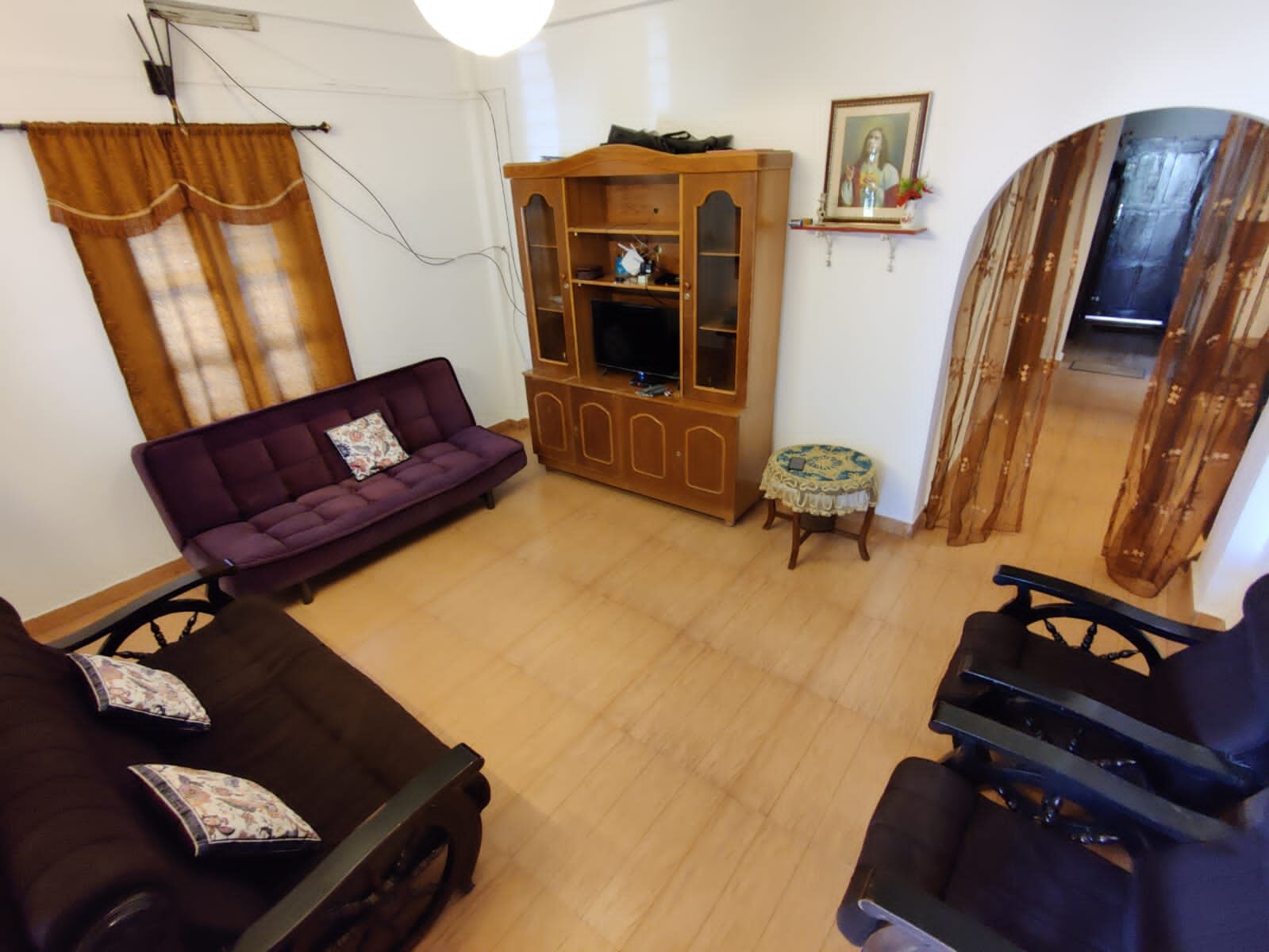 Living room with sofas and a wooden display cabinet